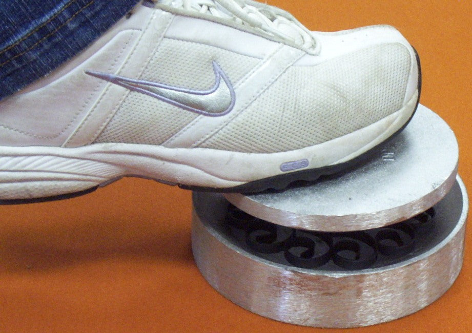 With flat Kosy ring welded up, it is placed in the female part of the Kosy Creations shallow dishing die set DDS. One presses together or as we show in photo, step on the male part of the set. By pushing down this rounds out the ring section.