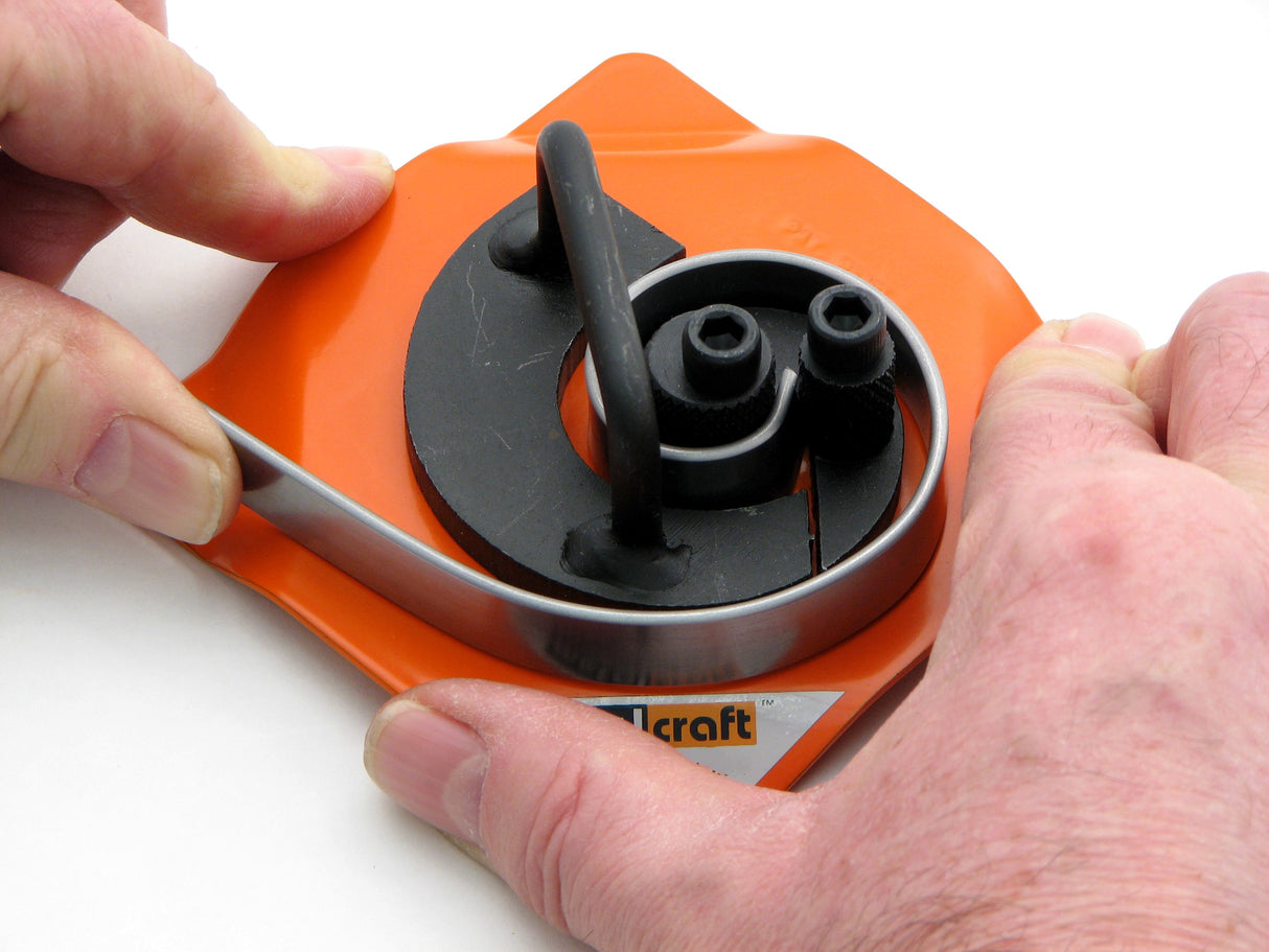 Hands shown forming scroll on Metalcraft MK1/2 Scroll Bender. Grip steel in center of scroll former and by hand pull around the inner fixed segment to make a smaller scroll.