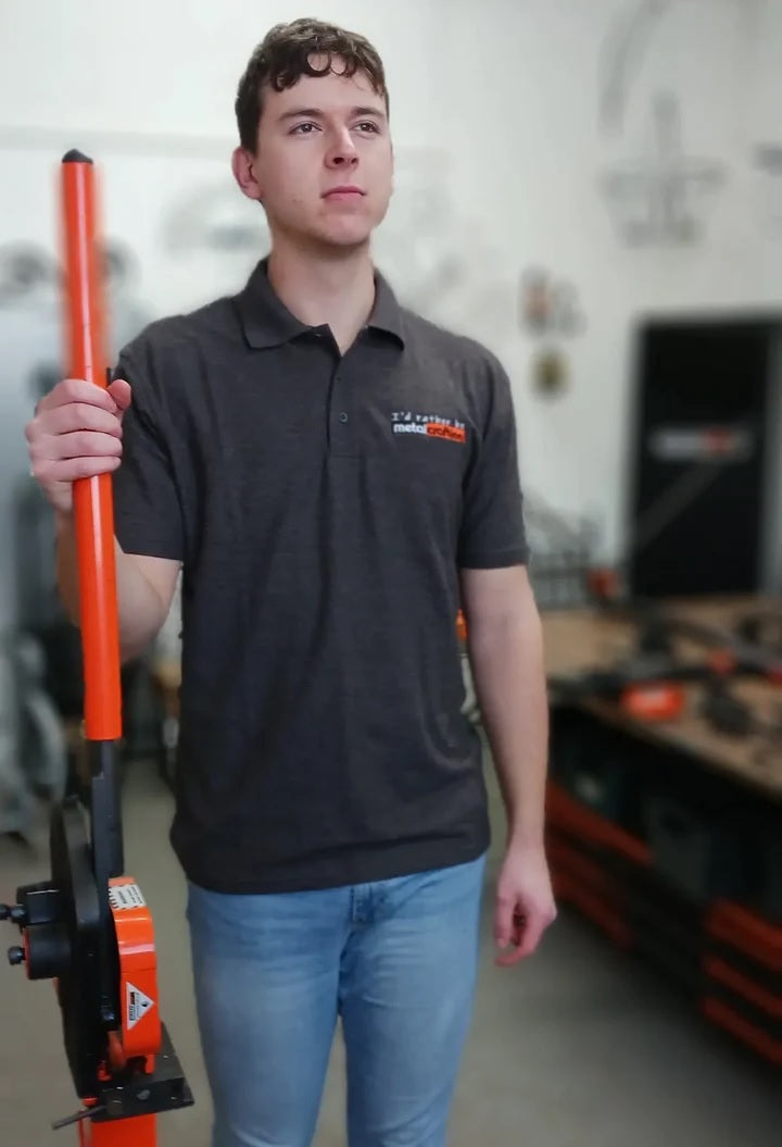 Individual modeling Dark Gray Collared T-Shirt embroidered with "I'd rather be metalcrafting"