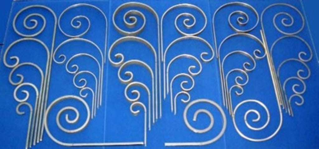 Variety of scrolls made using the Metalcraft Scroll Bender MK3/4 Former.  By interchanging scroll segments, different shaped scrolls can be produced.  Flat metal steel strip, Solid Round Rod, and Solid Square Bar.
