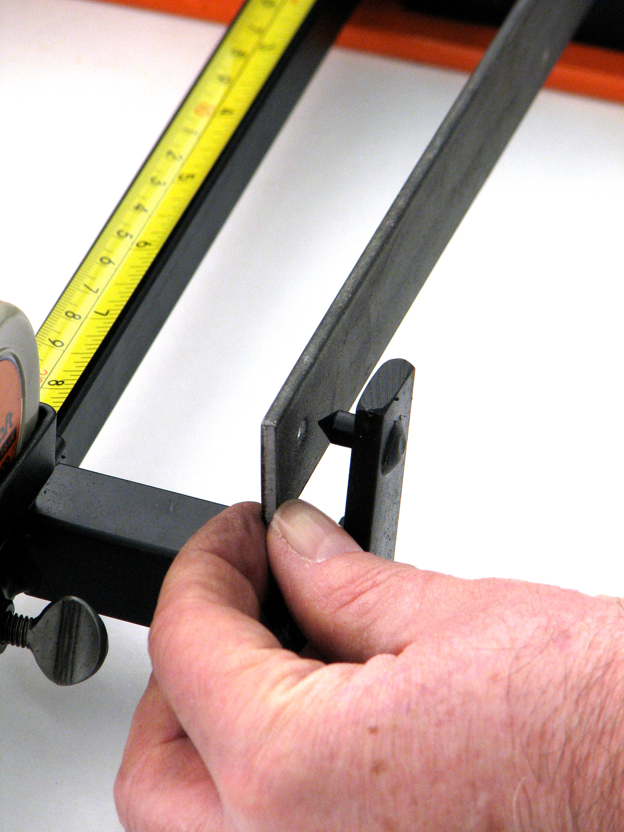 Closeup of hole being placed on pin to ensure there is equal distance between holes